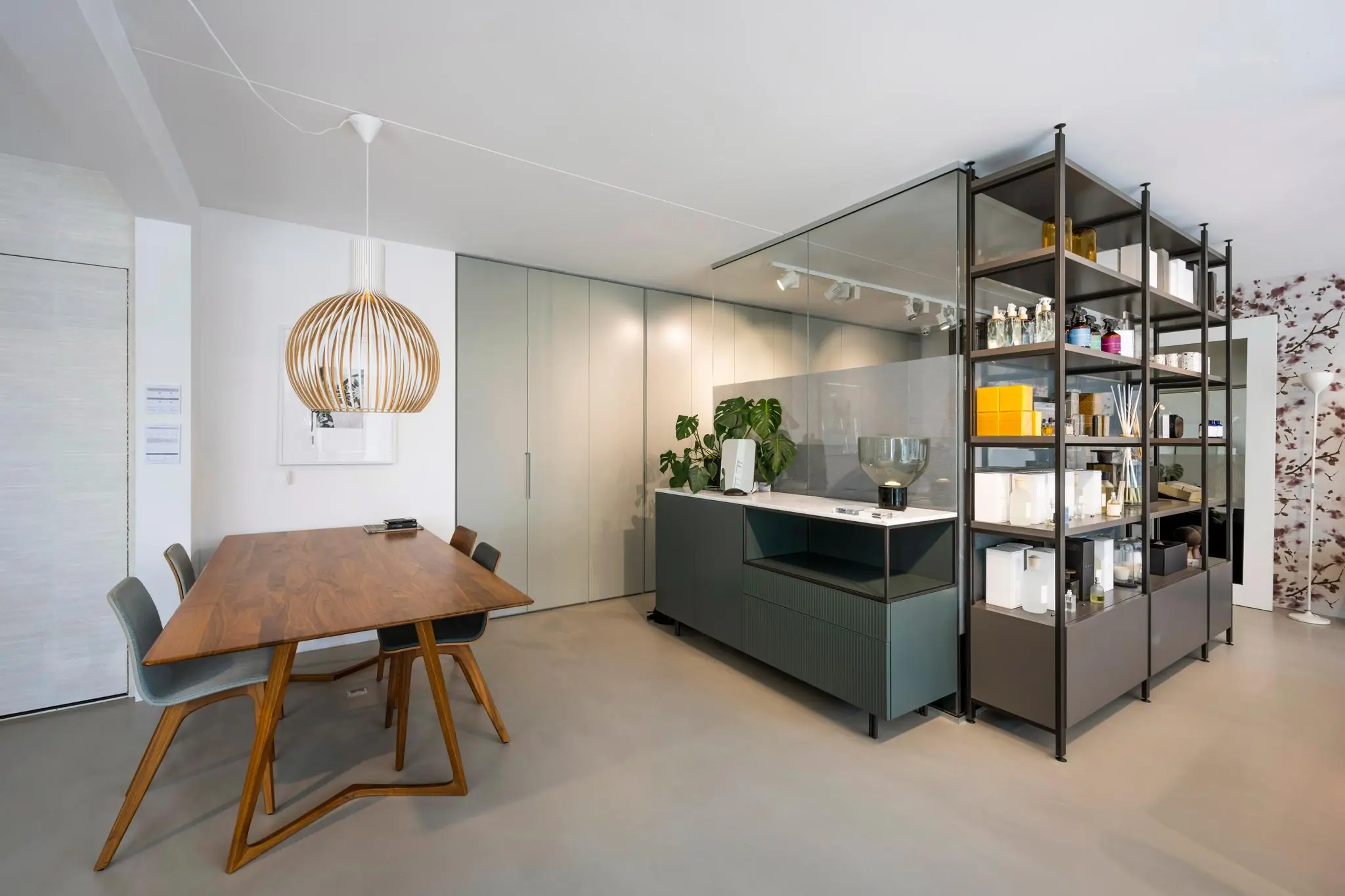 Moderne interieurfoto van een strakke keuken met open rekken, houten eettafel en designlamp aan de Oostelijke Handelskade.